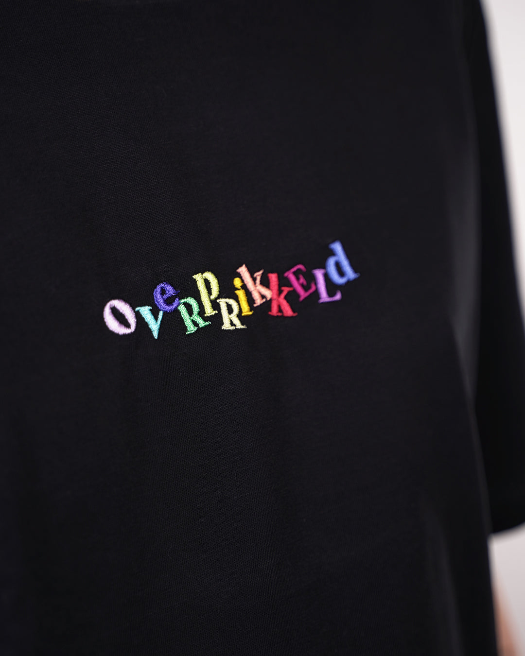 T-shirt Overprikkeld Regenboog – Zwart Unisex 100% Biologisch Katoen (Fair Wear)