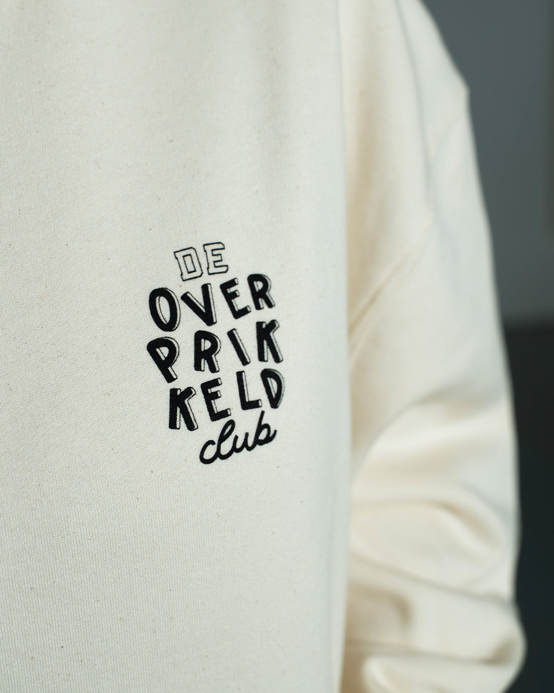 Hoodie ‘De Overprikkeld Club’ - Beige Unisex 85% Biologisch Katoen (Fair Wear)